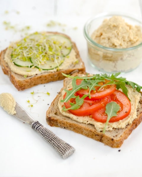 oil-free hummus on open face sandwiches with sliced tomatoes and cucumbers