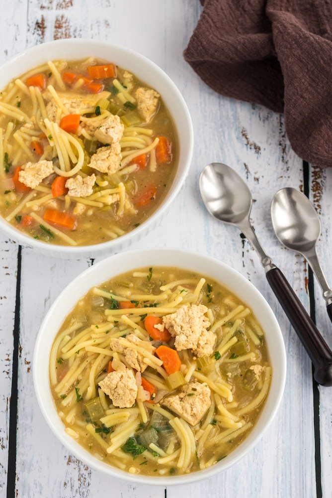 serving bowls with vegan chicken noodle soup