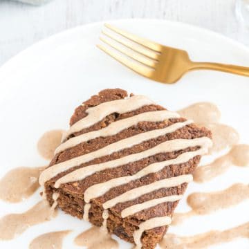 vegan spice cake on plate with cream drizzled over cake pieces and fork in cake